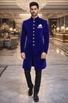 Traje étnico azul con botones dorados